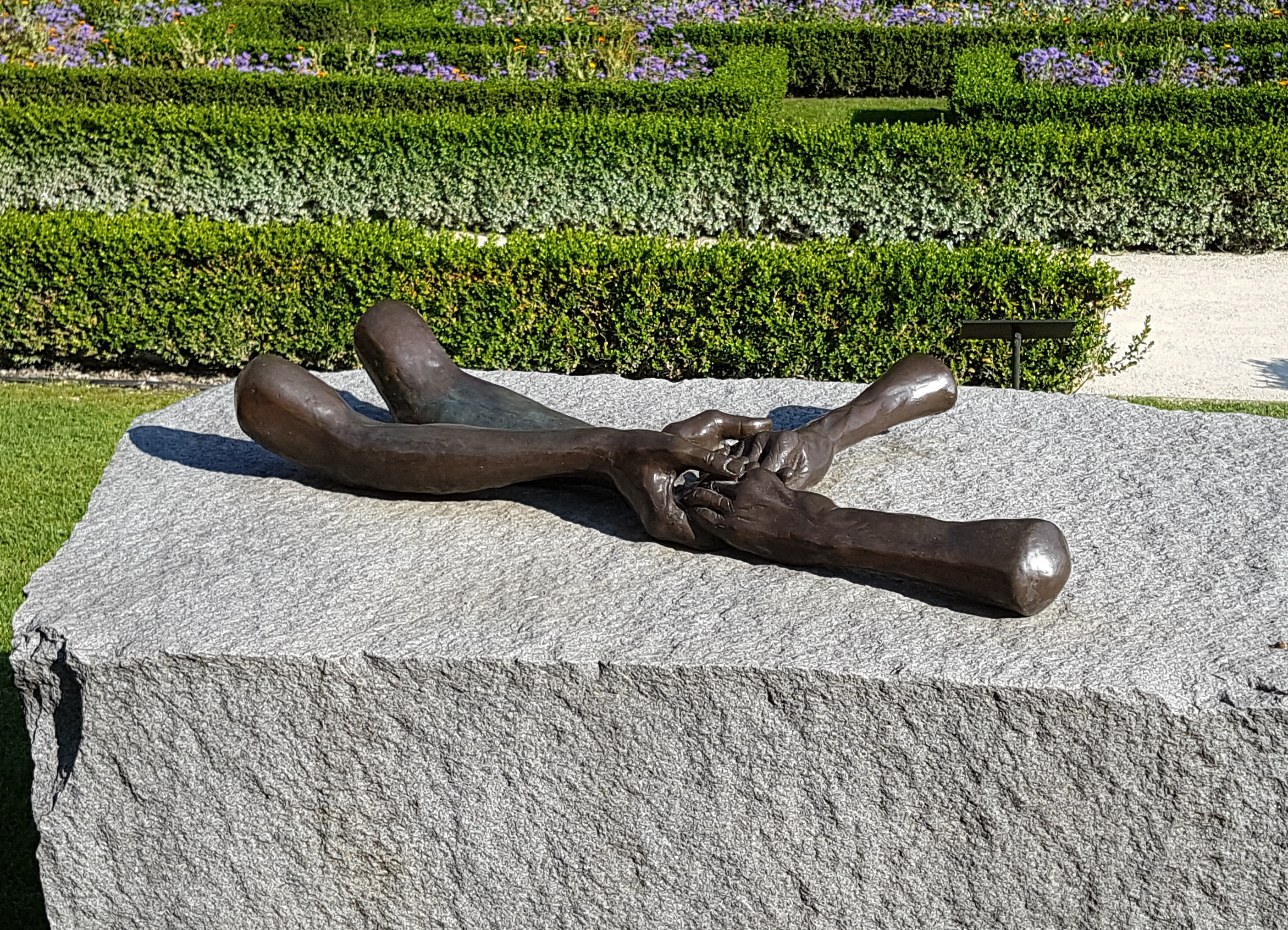 four bronze hands holding each other
